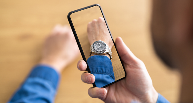 Man using iphone to try a watch on his wrist